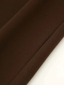 Close-up of the dark brown thick wool blend fabric texture on casual straight trousers