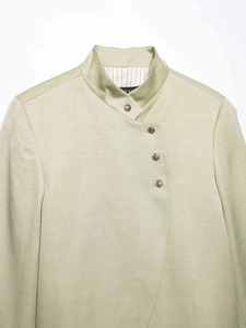 Detail view of khaki mandarin collar shirt featuring asymmetric bronze buttons and linen texture