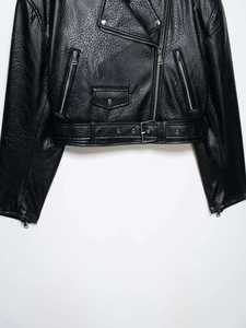 Detailed macro view of black lychee texture faux leather jacket with metallic zippers