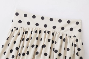 Détail de la jupe beige à pois avec taille plissée et texture de tissu fluide et lisse