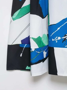 Detailed view of artistic abstract print and fine stitching on the pleated midi skirt hem