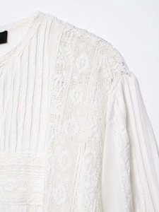 Detailaufnahme der weißen Baumwollbluse mit feiner Spitze und vertikalen Biesenfalten