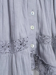 Close-up of lilac cotton camisole with pearlescent buttons and crochet lace detail