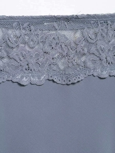 Close-up of intricate floral lace trim and smooth fabric on high-waist grey blue skirt