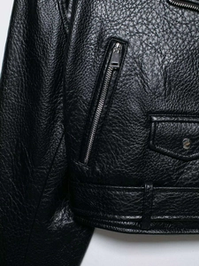Detailed macro view of black lychee grain faux leather texture and silver metal zipper