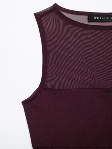 Detailed close-up of dark purple mesh patchwork and fine stitching on a bodysuit