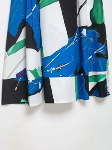 Detail view showing abstract floral print on high-quality woven pleated midi skirt fabric