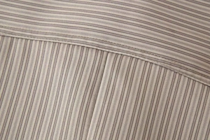 Vue détaillée de la texture rayée grise et des coutures de précision sur la veste