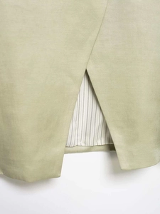 Detailed macro view of the light khaki shirt hem with side slit and striped lining