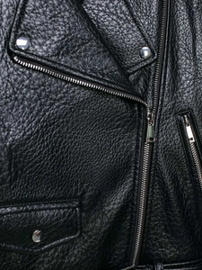 Close-up of black litchi texture leather jacket with silver zippers and metal studs