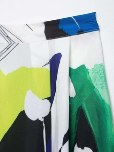 Close-up detail of abstract artistic print midi skirt with pleats and vibrant splash pattern