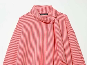 Detail of pink and white striped poplin shirt with a tied scarf neckline and collar