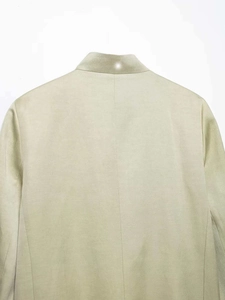 Detail showing the stand collar stitching and linen texture of the khaki shirt jacket