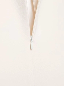 Détail du zip invisible sur une robe courte blanc crème avec manches bouffantes