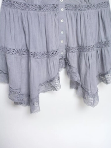 Detail of lavender camisole with delicate lace patchwork, buttons and ruffled hem