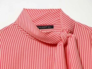 Detail shot of the striped poplin shirt neckline with tie-neck and brand size label