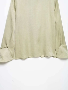 Detail of flared cuffs and vintage metal button on light green cotton linen blazer
