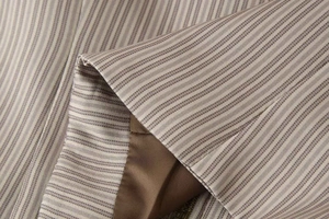 Détail de la texture à rayures avec doublure lisse et fermeture éclair de la veste cargo