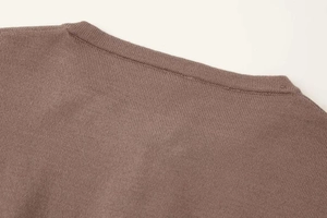 Detail of fine ribbed neckline on a dark brown knit cardigan with seamless stitching