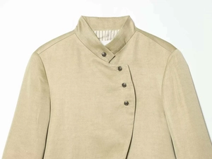 Detailed view of khaki fabric texture and embossed metal buttons on a blazer neck