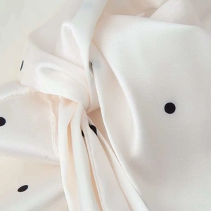 Polka dot satin scarf blouse in creamy white featuring silky texture and elegant drape