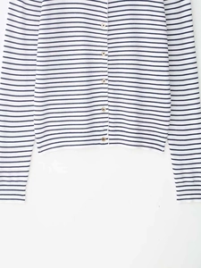 Dettaglio del cardigan in maglia a righe blu e bianche con bottoni rifiniti in legno
