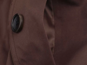 Detail shot of dark brown twill fabric texture and fine stitching with a round button