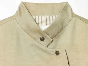 Detail of light khaki blazer lapel with antique bronze buttons and striped lining