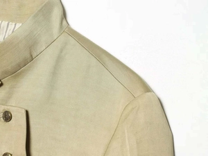 Detail of khaki jacket showing vintage embossed metal button and striped inner lining