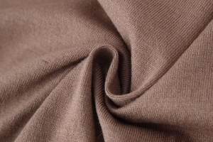 Close-up of premium dark brown knitted fabric showing soft texture and fine stitching