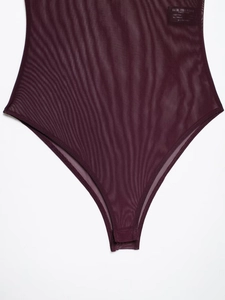 Detailed close-up of dark burgundy mesh bodysuit showing sheer fabric and high-cut stitching