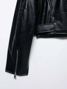 Detailed close-up of black pebble leather texture and silver zipper on jacket cuff