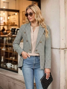 Detail of a chic houndstooth blazer with double-breasted buttons in an urban street setting