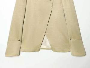 Close-up of asymmetric hem and striped lining on khaki blazer sleeve and cuff