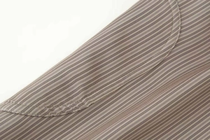 Détail de la texture du tissu à rayures et coutures incurvées de précision sur un costume
