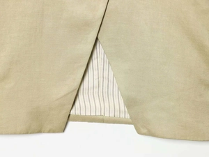 Detail view of khaki blazer featuring back slit design and striped interior lining