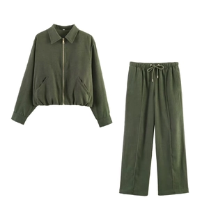 Flat lay of olive green pilot jacket with zipper and matching wide-leg drawstring trousers