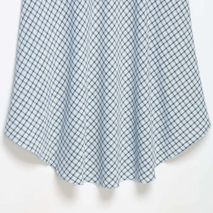 Jupe à carreaux bleu et blanc avec ourlet arrondi asymétrique et tissu léger