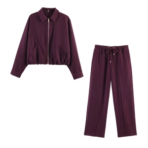 Detail of dark burgundy two-piece set featuring lapel zip jacket and trousers with front crease