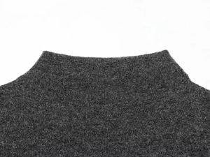 Dettaglio del collo alto su un abito in maglia grigio scuro con texture pregiata