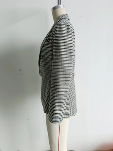 Detail of green and white houndstooth tweed blazer featuring a classic notched lapel