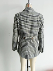 Detail of dark green plaid blazer with back waist strap and amber buttons on a mannequin