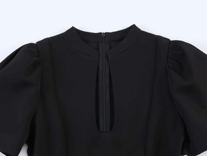 Detail of round neckline with slit and puff sleeves on black elegant dress