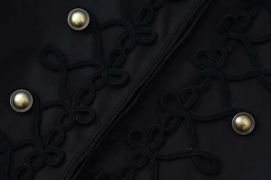 Close-up of black blazer with intricate braided rope toggles and gold metallic buttons