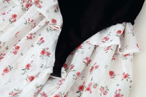 Detail of floral print fabric with velvet stitching and ruffled waistline tie design