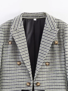 Detail of green and black plaid blazer showing double-breasted amber buttons and size label