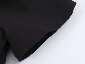 Detailed view of the smooth black fabric texture and neat stitching on bubble sleeve dress