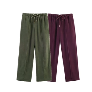 Detail of high-waist straight-leg trousers with drawstring waist and stitched front seams