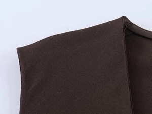 Détail du tissu tissé café foncé et des coutures sur un haut sans manches minimaliste