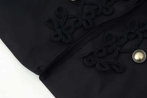Detailed close-up of ethnic style black cord knot embroidery and bronze metal button on blazer